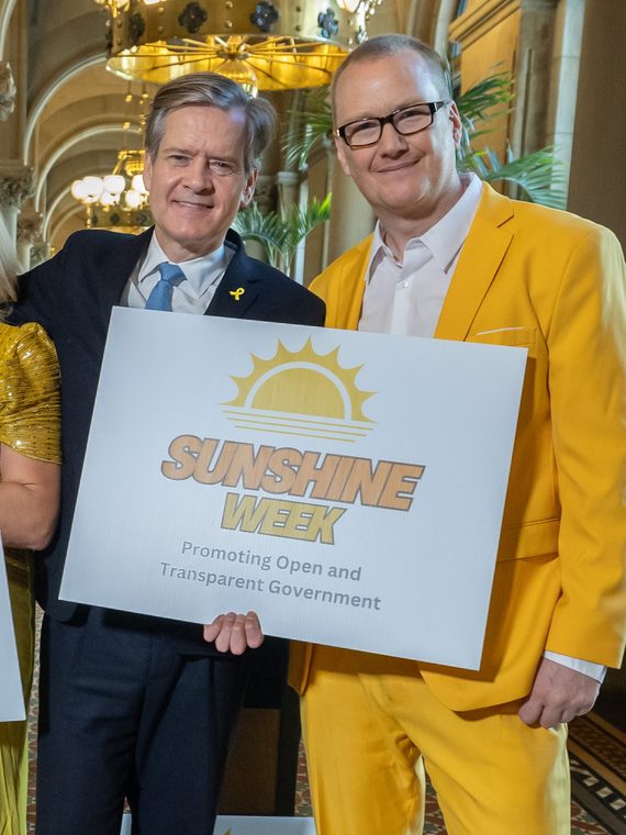 A New York State senator and a NYCOG member holding a Sunshine Week sign at the Capitol